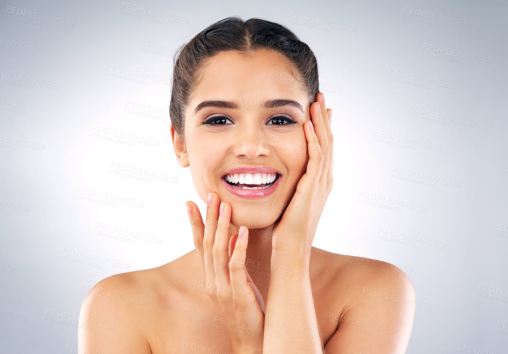 Buy stock photo Studio portrait of a beautiful young woman with gorgeous skin holding her face against a grey background