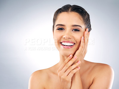 Buy stock photo Studio portrait of a beautiful young woman with gorgeous skin holding her face against a grey background