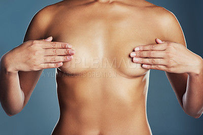 Buy stock photo Studio shot of an unrecognizable woman examining her breasts against a grey background