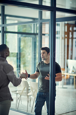 Buy stock photo Shot of two young businessmen having an argument in a modern office