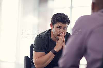 Buy stock photo Shot of an unhappy young man talking with a colleague