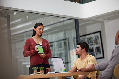 Buy stock photo Shot of a young businesswoman using a digital tablet during a meeting with colleagues in a modern office
