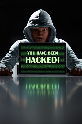 Buy stock photo Shot of a young hacker using a laptop with the words “You have been hacked” on it