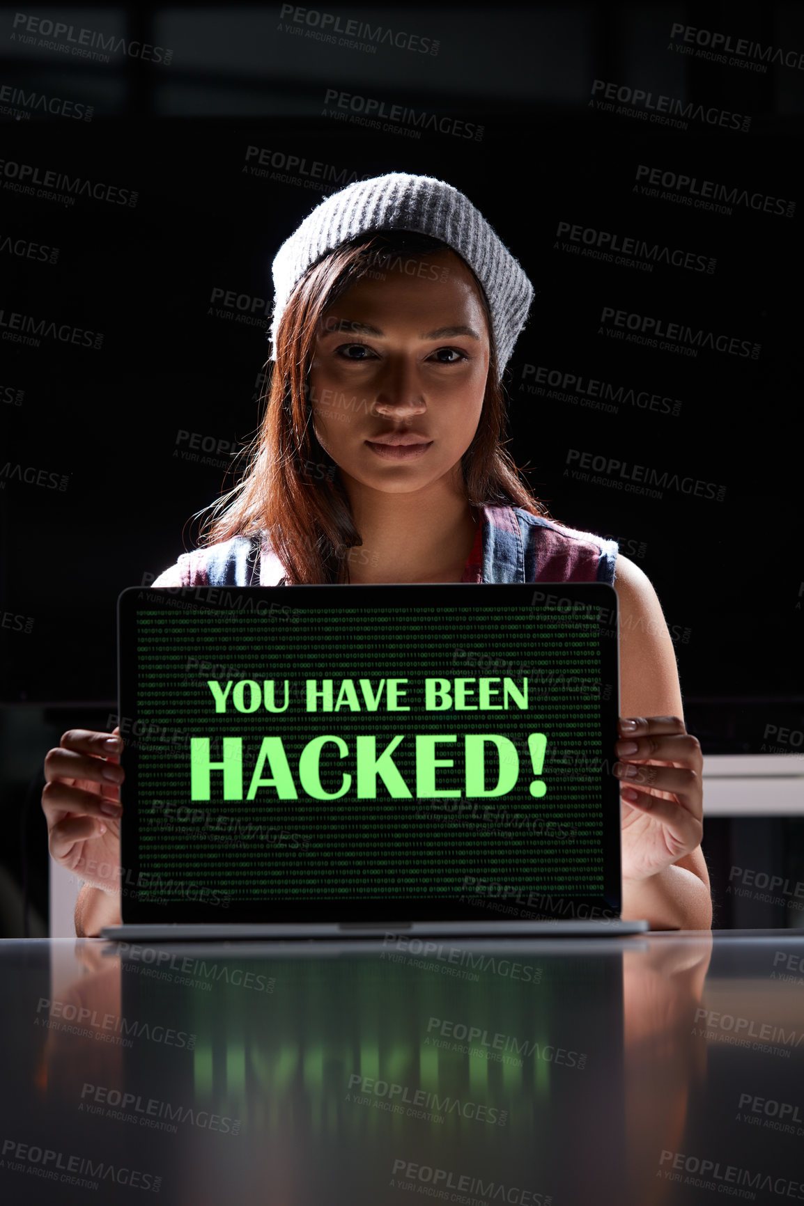 Buy stock photo Shot of a young female hacker using a laptop with the words “You have been hacked” on it