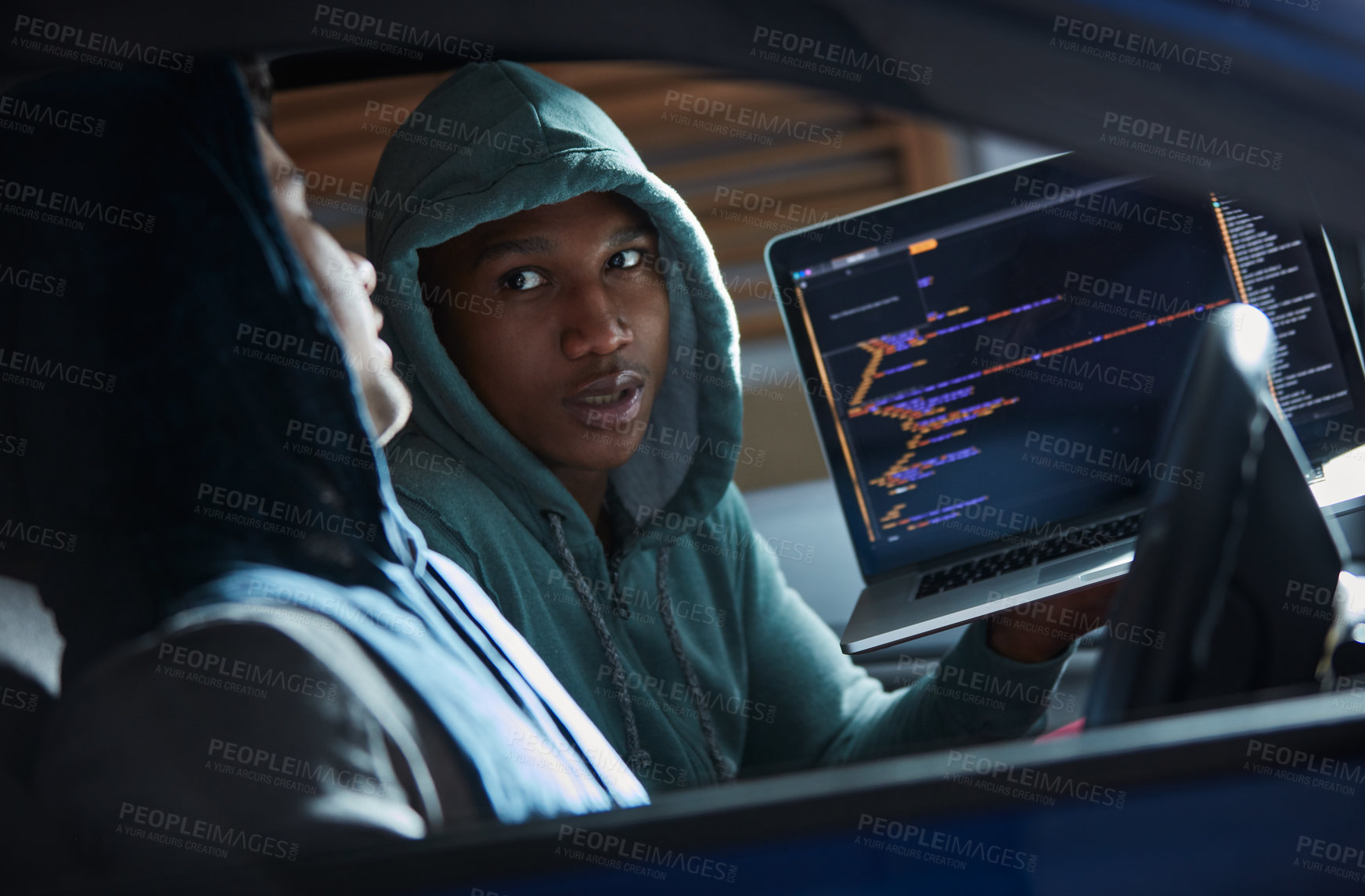 Buy stock photo Shot of two young hackers using a laptop in a car