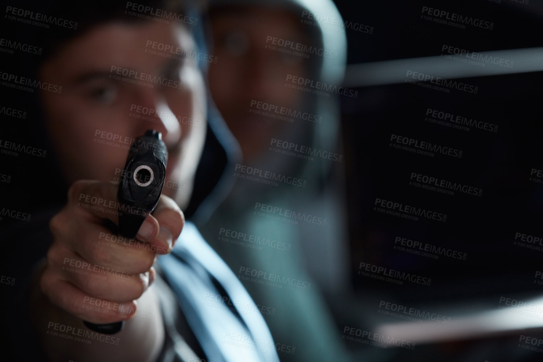 Buy stock photo Shot of two men sitting in a car and pointing a gun