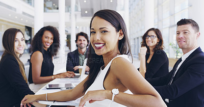 Buy stock photo Cropped shot of a young businesswoman smiling in an office during a meeting with her colleagues in the background