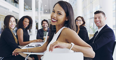 Buy stock photo Cropped shot of a young businesswoman smiling in an office during a meeting with her colleagues in the background