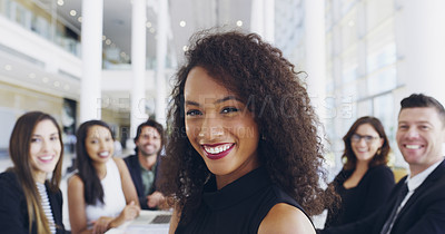 Buy stock photo Cropped shot of a young businesswoman smiling in an office during a meeting with her colleagues in the background