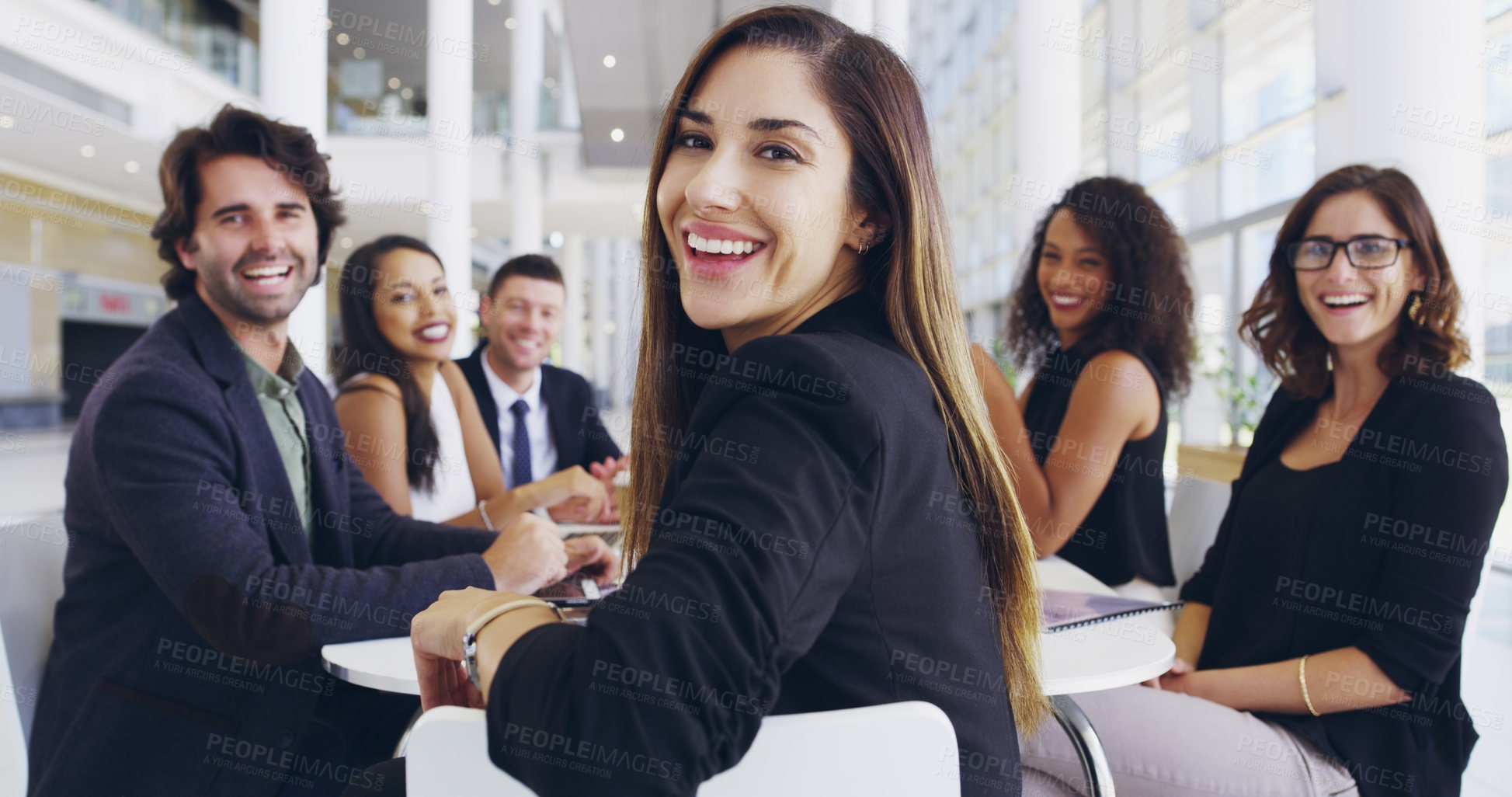 Buy stock photo Cropped shot of a young businesswoman smiling in an office during a meeting with her colleagues in the background