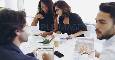 Buy stock photo Cropped shot of a group of businesspeople sitting around the boardroom table during a meeting