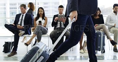 Buy stock photo Cropped shot of an unrecognizable businessman walking through an airport with his luggage