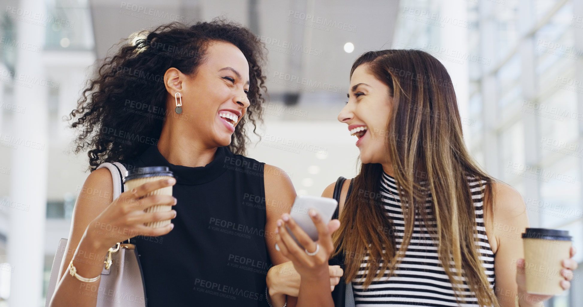 Buy stock photo Cropped shot of two young businesswomen chatting and using a smartphone while walking in an office on a coffee break
