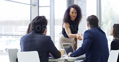 Buy stock photo Cropped shot of a businesswoman shaking hands with colleagues during a meeting in an office