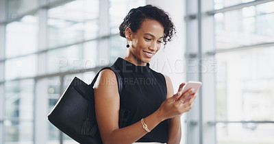 Buy stock photo Cropped shot of a young businesswoman using a smartphone and waving while walking through a modern office