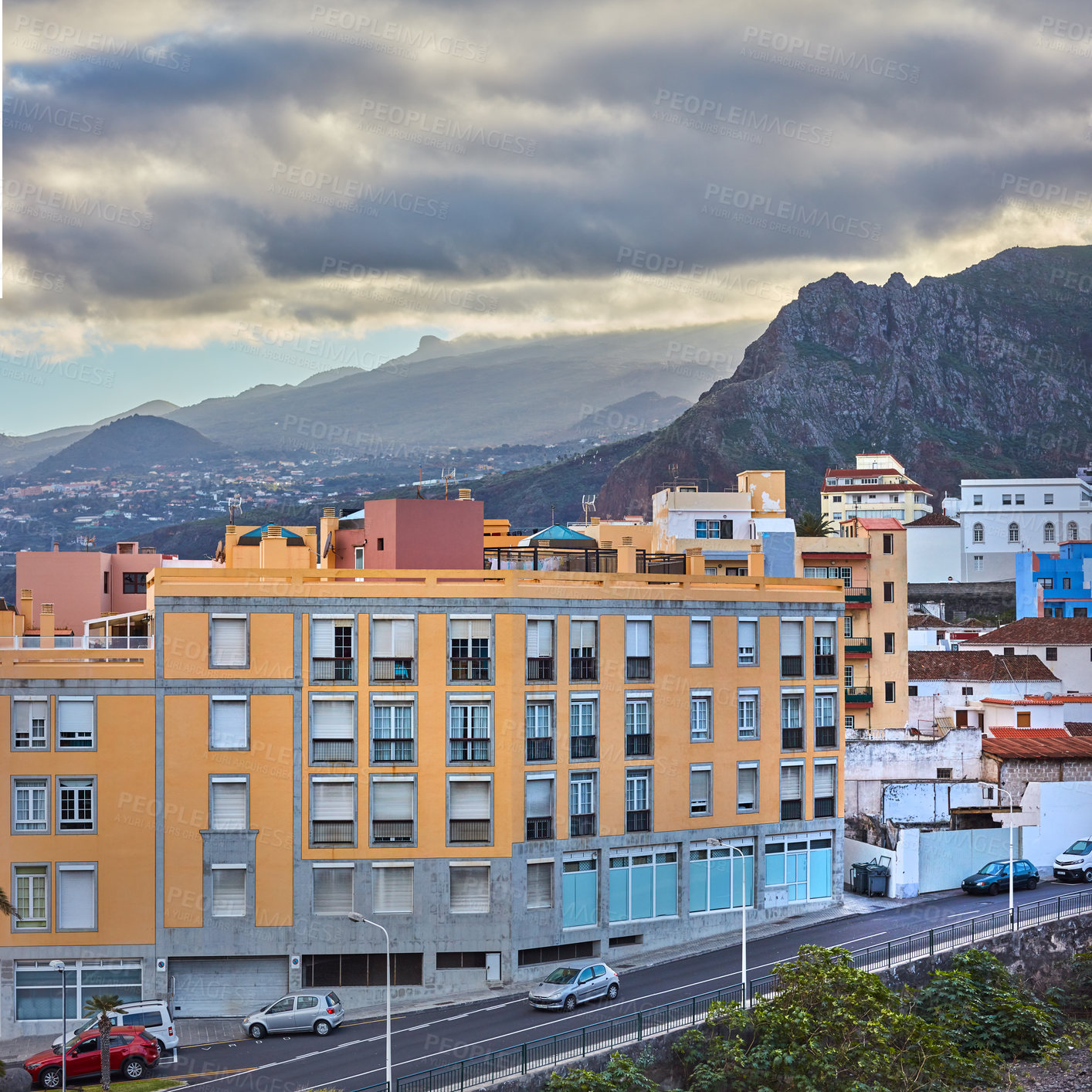 Buy stock photo Scenic landscape view of vibrant houses, traditional residential buildings or city structures. Tourism destination street on Santa Cruz road, La Palma, Spain with background mountains and cloudy sky