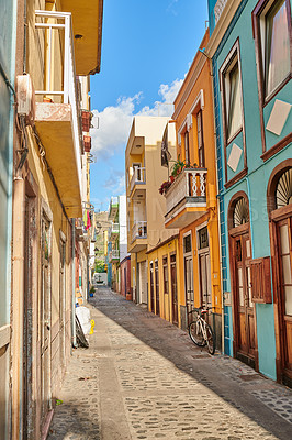 Buy stock photo Narrow street between colorful buildings in Santa Cruz de La Palma. Bright and vibrant classical architecture in a small city or village. Beautiful houses or homes with a vintage design