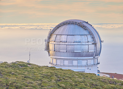 Buy stock photo Closeup of an astronomical observatory with clear sky and copy space. Telescope surrounded by greenery and located on an island at the edge of a cliff. Roque de los Muchachos Observatory in La Palma