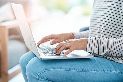 Buy stock photo Cropped shot of an unrecognizable young woman using her laptop at home