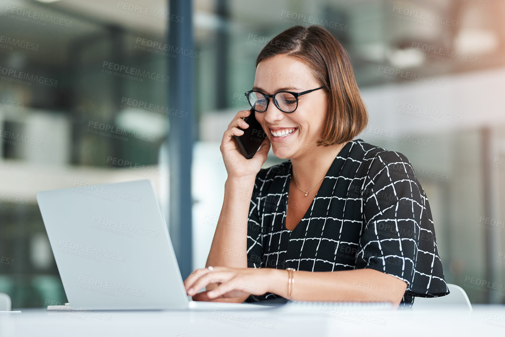Buy stock photo Cropped shot of a happy young businesswoman taking a call while working in an office