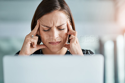 Buy stock photo Cropped shot of a young businesswoman suffering with a headache while working in an office