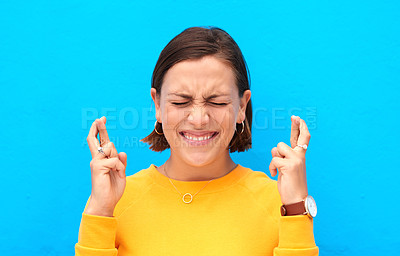 Buy stock photo Cropped shot of a young woman crossing fingers against a blue background