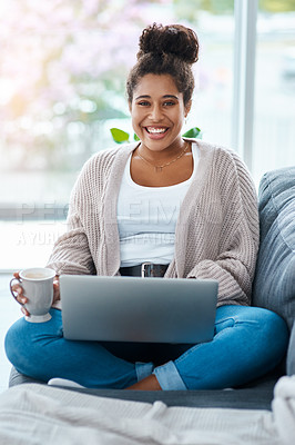 Buy stock photo Cropped portrait of an attractive young woman using her laptop while having coffee in her living room