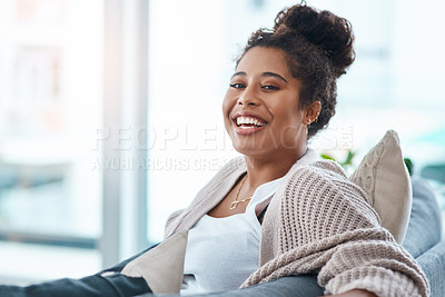 Buy stock photo Cropped portrait of a happy young woman relaxing on her couch at home