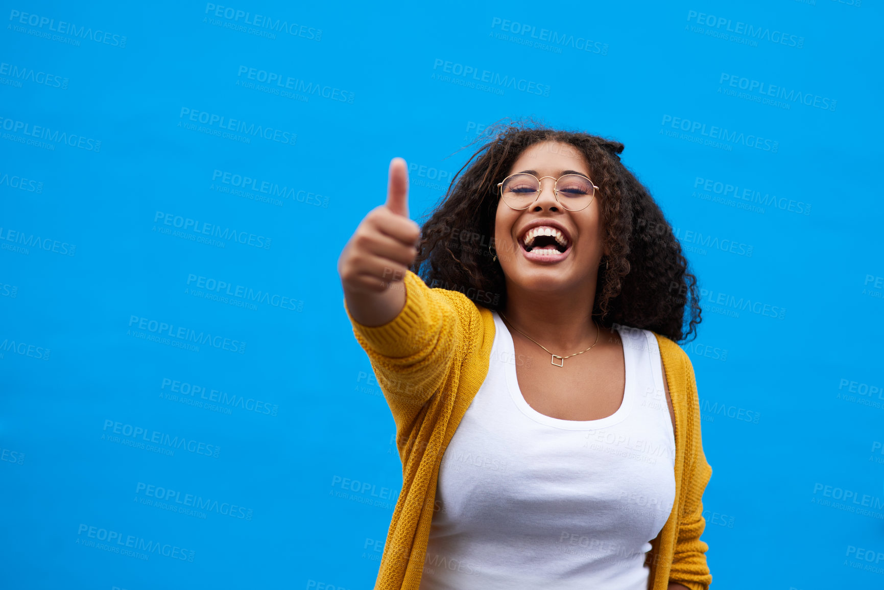 Buy stock photo Happy, thumbs up and portrait of woman in studio with mockup space for approval, vote or opinion. Excited, confident and female student from Mexico with agreement hand gesture by blue background.