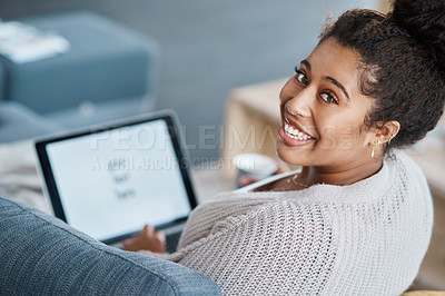 Buy stock photo Cropped portrait of an attractive young woman using her laptop on the sofa at home