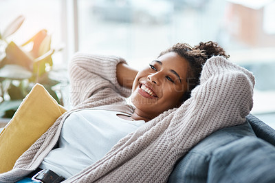Buy stock photo Cropped portrait of an attractive young woman relaxing on her couch at home