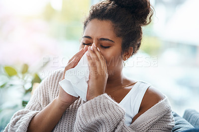 Buy stock photo Sick, virus and a woman blowing nose on the sofa with covid, hay fever or allergies in a house. Flu, young lady and an allergy, sinus problem or sneezing into a tissue on the living room couch