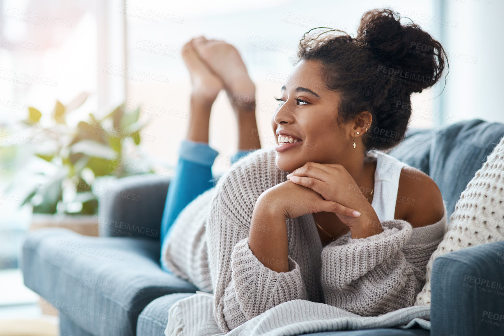 Buy stock photo Full length shot of a happy young woman relaxing on her couch at home