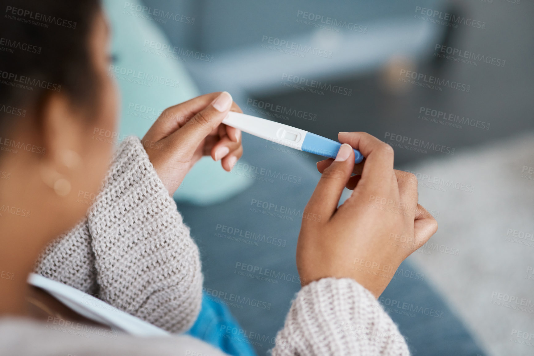 Buy stock photo Pregnancy test, woman hands and waiting at home for results on a living room couch. House, female person and hand with medical and fertility testing stick to show pregnant sign alone on lounge sofa 