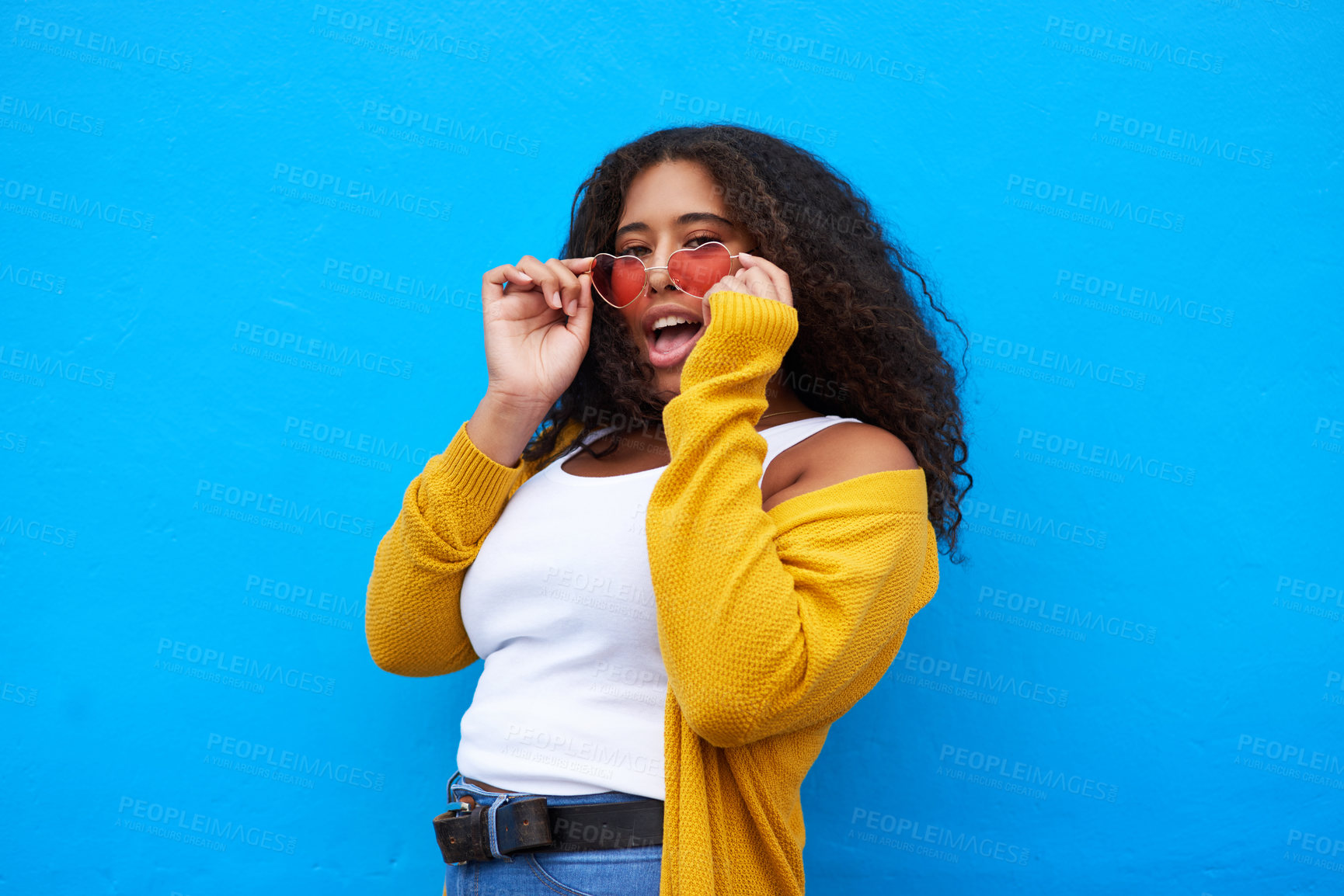 Buy stock photo Cropped portrait of an attractive young woman posing seductively against a blue background