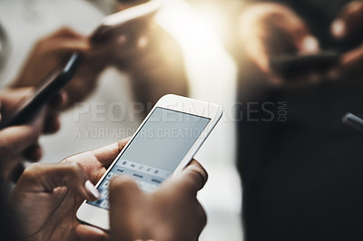 Buy stock photo Cropped shot of a group of unrecognizable businesspeople texting on their phones at work