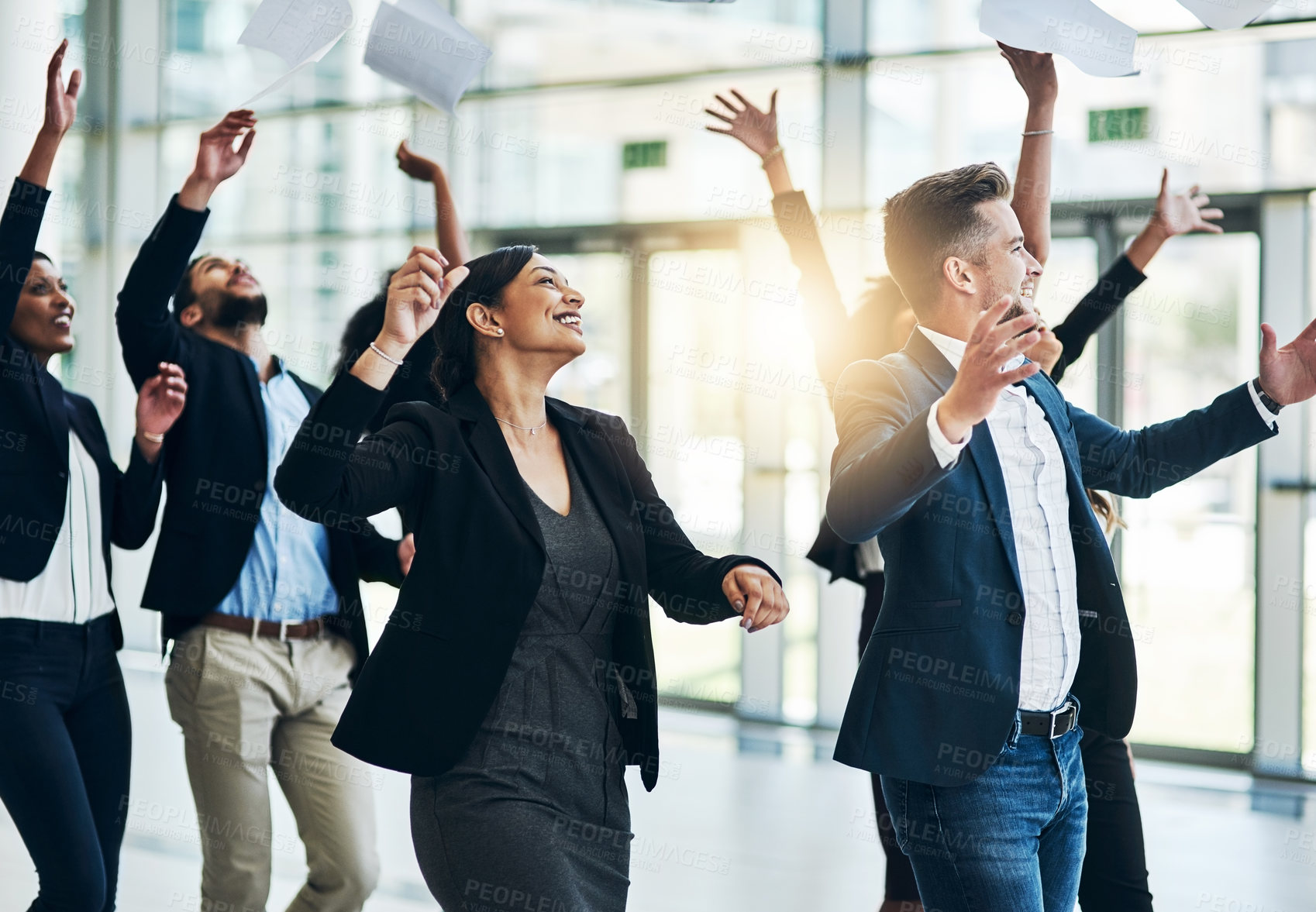 Buy stock photo Shot of a group of cheerful businesspeople lifting their hands in joy while being funny inside of the office at work