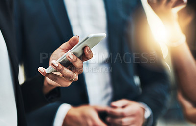 Buy stock photo Cropped shot of a group of unrecognizable businesspeople texting on their phones at work