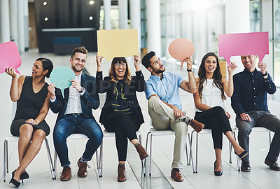 Buy stock photo Shot of a group of cheerful businesspeople holding up speech bubbles inside of the office during the day