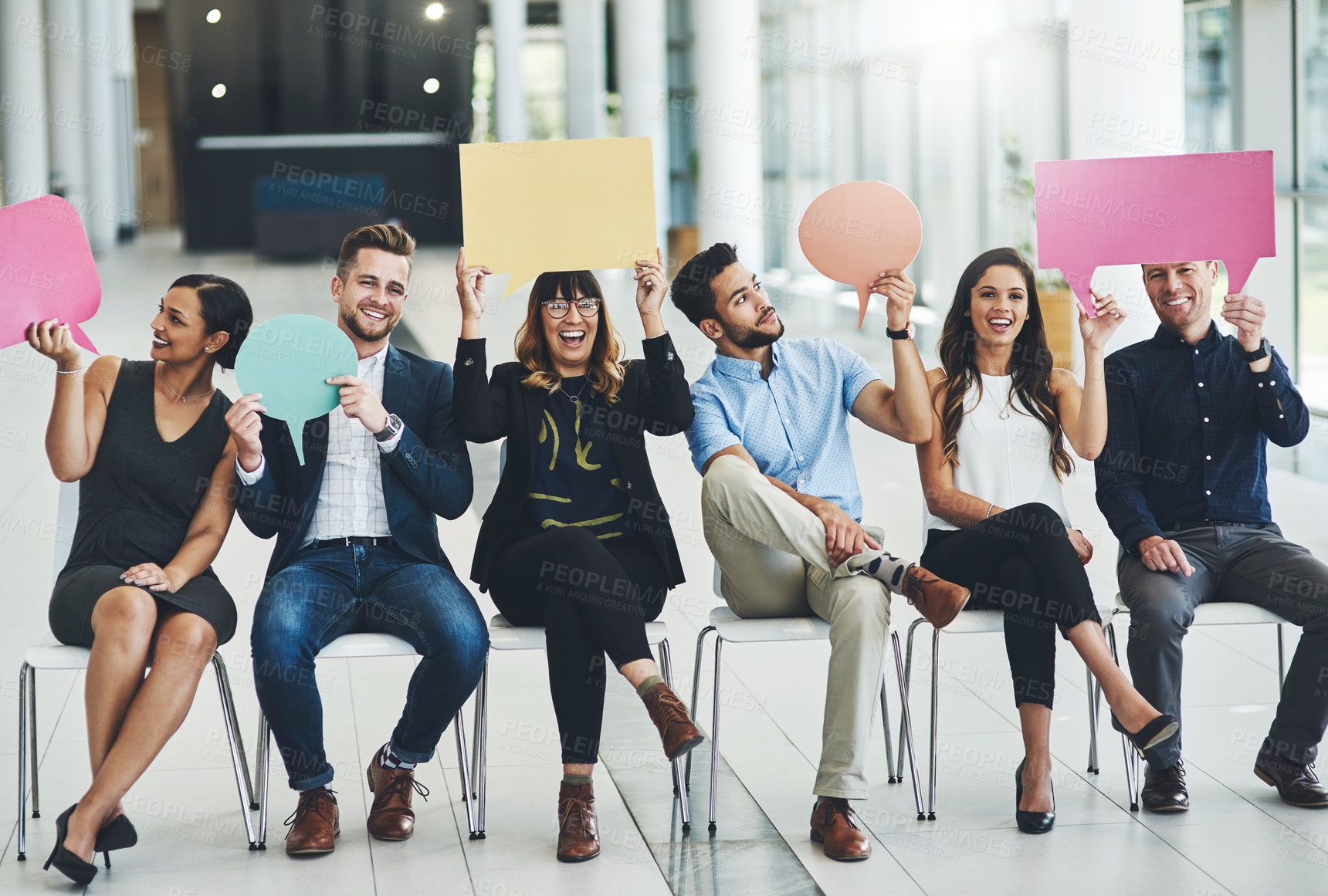 Buy stock photo Shot of a group of cheerful businesspeople holding up speech bubbles inside of the office during the day
