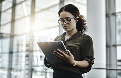 Buy stock photo Cropped shot of an attractive young businesswoman using a digital tablet in a modern office
