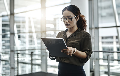 Buy stock photo Cropped shot of an attractive young businesswoman using a digital tablet in a modern office