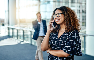 Buy stock photo Cropped shot of an attractive young businesswoman taking a phonecall while standing in a modern workplace