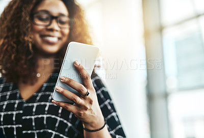 Buy stock photo Cropped shot of an unrecognizable businesswoman using a smartphone in a modern office
