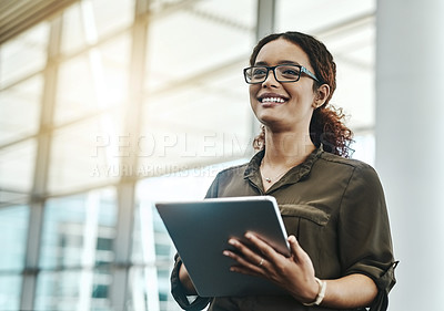 Buy stock photo Cropped shot of an attractive young businesswoman smiling while using a digital tablet in a modern office