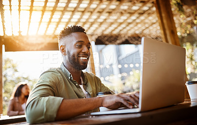 Buy stock photo Cropped shot of a handsome young man using a laptop in a coffee shop