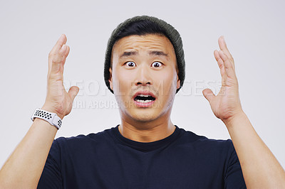 Buy stock photo Studio portrait of a handsome young man looking shocked against a grey background