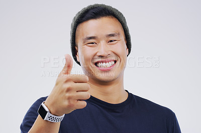 Buy stock photo Studio portrait of a handsome young man giving a thumbs up against a grey background