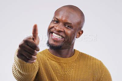 Buy stock photo Studio portrait of a handsome young man giving a thumbs up against a grey background