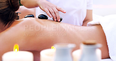Buy stock photo Shot of an unrecognizable woman getting a hot stone massage at a spa